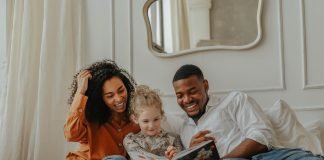 Becoming Parents: The Pathway to Adoption Unboxed a family reading a book on the bed